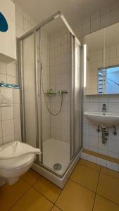 a bathroom with a shower and a toilet and a sink at Accumer EE in Langeoog