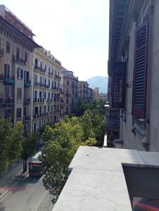 a view of a city street with buildings and a bus at Sunset hostel Palermo in Palermo
