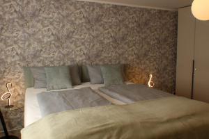 a bedroom with a large bed with two pillows at Ferienwohnungen Augustinerhof in Quedlinburg