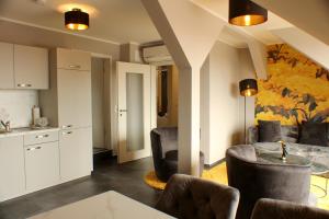 a living room with chairs and a table and a kitchen at Ferienwohnungen Augustinerhof in Quedlinburg +81 photos