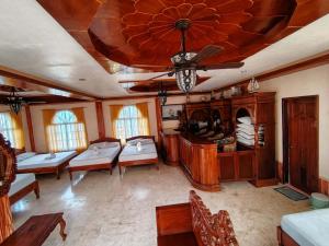 a living room with couches and a ceiling at Amerie Rae Resort in Bangui +5 photos