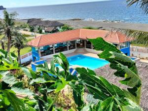 an aerial view of a house with a swimming pool and the ocean at Amerie Rae Resort in Bangui