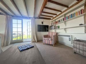 a living room with a chair and a window at Prospect Cottage in Wittersham