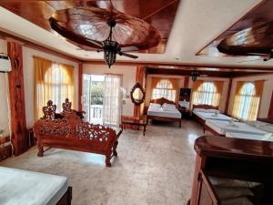a large room with two beds and a ceiling at Amerie Rae Resort in Bangui