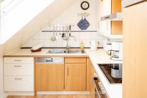 a kitchen with white cabinets and a sink at Freesenhoff - Ofdak in Langeoog