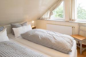 a bedroom with two beds and a window at Freesenhoff - Ofdak in Langeoog