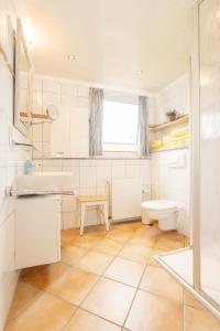 a white bathroom with a sink and a toilet at Freesenhoff - Ofdak in Langeoog