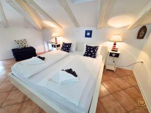 a large white bed in a room with two lamps at Apartment Blue Whale in Piran