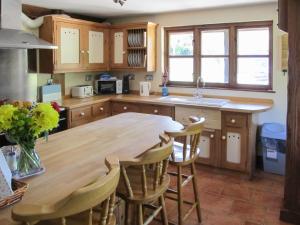 a kitchen with a wooden table and chairs at Maytree Cottage in East Dereham