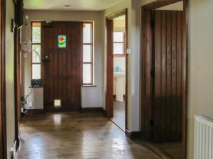 an empty hallway with a door and a window at Maytree Cottage in East Dereham