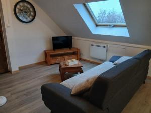 a living room with a couch and a tv at La cabane de Lancelot Loubliette in Laperrière-sur-Saône