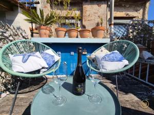 a table with a bottle of wine and two glasses at Apartment Blue Whale in Piran