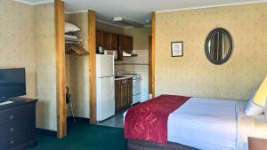 a hotel room with a bed and a kitchen at Studio 6 Lake George NY Adirondacks in Lake George