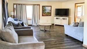a living room with two couches and a flat screen tv at Studio 6 Lake George NY Adirondacks in Lake George