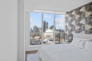 a bedroom with a large window with a city view at Panoramic Lakeview Resort Living 3BDR with Gym, Pool, Free parking in Toronto +49 photos