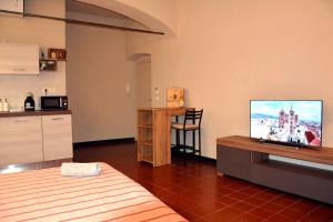 a room with a bed and a television on a table at Ca' di Beppe in Albenga
