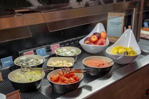 a buffet line with bowls of different types of food at Hotel Austria by Pierre & Vacances in Soldeu +33 photos