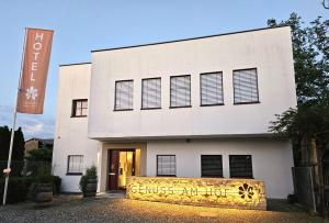 a white building with a sign in front of it at Genuss Am Hof in Halbturn