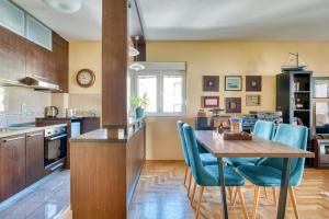 a kitchen with a wooden table and blue chairs at World Traveler Nest in Kotor