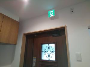 a sign above a door with a window above it at わんぱくポケット in Tenjin