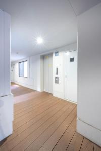 an empty room with white walls and wooden floors at BK Residence Kawasaki in Kawasaki +1 photo