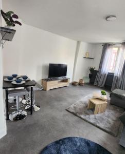 a living room with a couch and a television at Charmant logement hyper centre in Sélestat