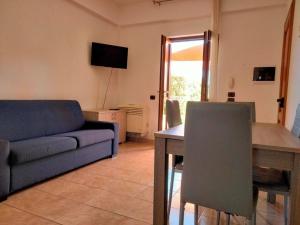 a living room with a blue couch and a table at Afrodite Home in Solfara Mare