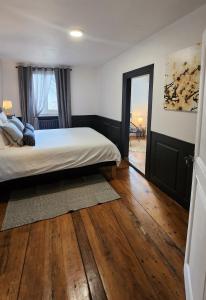 a bedroom with a bed and a wooden floor at Charmant logement hyper centre in Sélestat