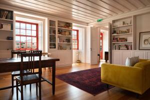 a living room with a table and a yellow couch at Casa Dr Ramiro Salgado - Douro Superior, Torre de Moncorvo in Torre de Moncorvo