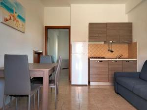 a kitchen and dining room with a table and a couch at Afrodite Home in Solfara Mare
