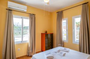 a bedroom with a bed and two windows at La terraza de Albatros in La Isleta del Moro
