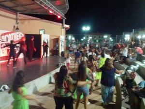 a crowd of people standing on a stage at night at Afrodite Home in Solfara Mare