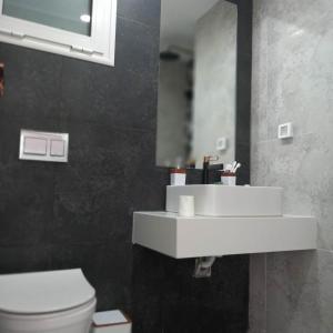 a bathroom with a white sink and a toilet at Appartement Galaxy Hammamet in Hammamet Sud +7 photos