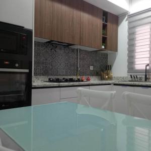 a kitchen with a glass counter top and wooden cabinets at Appartement Galaxy Hammamet in Hammamet Sud