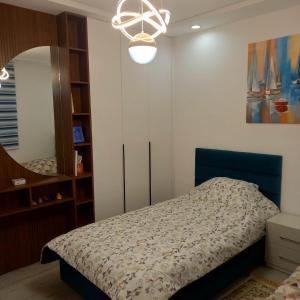 a bedroom with a bed and a mirror at Appartement Galaxy Hammamet in Hammamet Sud