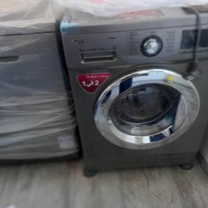 a washing machine sitting on the floor next to a bed at Appartement Galaxy Hammamet in Hammamet Sud