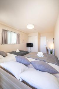 a bedroom with three beds with pillows on them at BK Residence Kawasaki in Kawasaki