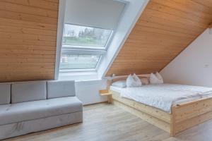 a bedroom with a bed and a couch and a window at Tourist farm Mulej in Bled