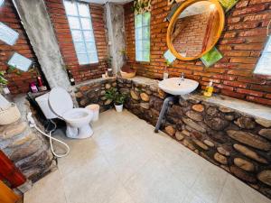 a stone bathroom with a toilet and a sink at Lakey Views Sumbawa in Huu +38 photos