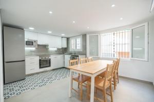 a kitchen with a wooden table and chairs at Casa Ingravita - Oceanfront Tranquility in Cunit
