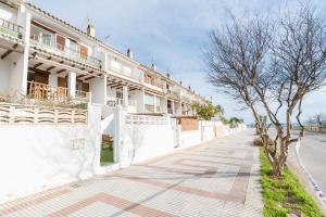 a white building with trees on the side of a street at Casa Ingravita - Oceanfront Tranquility in Cunit