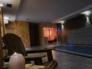 a room with a swimming pool with a chair and a candle at Wellness hotel - Viktorka, herecký dům in Česká Skalice