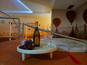 a table with two glasses and a bottle of wine and grapes at Wellness hotel - Viktorka, herecký dům in Česká Skalice