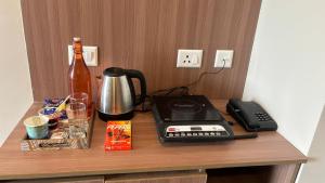 a desk with a telephone and a bottle on it at The Pineapple Suite with Gorgeous Views in Greater Noida