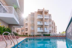 a swimming pool in front of a building at Appartement Galaxy Hammamet in Hammamet Sud
