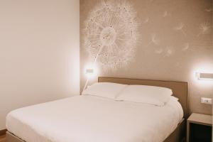 a bedroom with a white bed and a painting on the wall at Ca' Perenzin in Tarzo