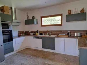 a kitchen with white cabinets and a window at L'Echo de la Nature in Sasseville