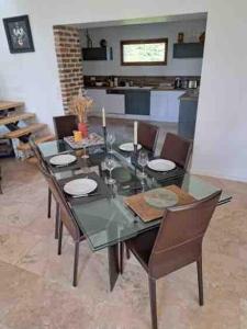 a dining room with a glass table and chairs at L'Echo de la Nature in Sasseville