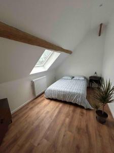 an attic bedroom with a bed and a potted plant at L'Echo de la Nature in Sasseville