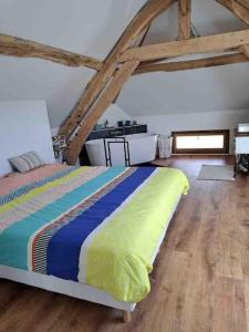 a bedroom with a bed and a wooden floor at L'Echo de la Nature in Sasseville